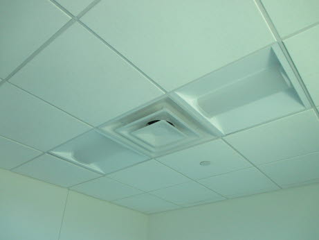 A diffuser with fluorescent lights in a drop ceiling.