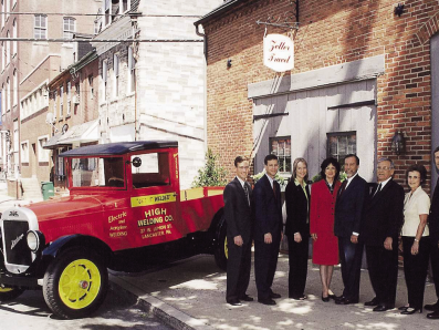 Members of the High Family stand in front of Zeller Travel which currently occupies the building that was the first home of High Welding Company. Pictured with the Family is the red High Welding Company REO, a replica of the original truck owned by founder Sanford High in 1931.